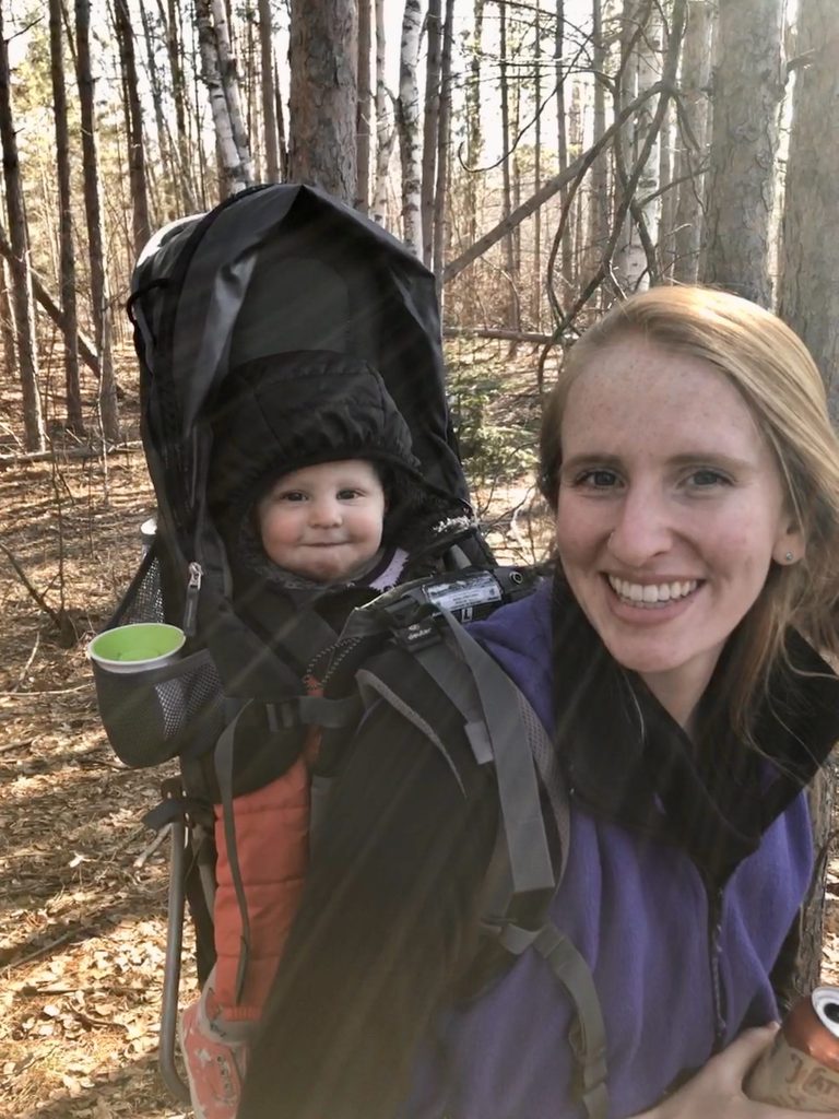 woman wearing a backpack with a baby in it