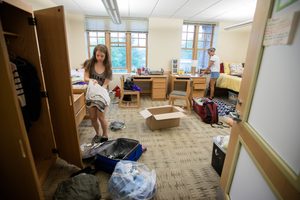 two students moving into a dorm room