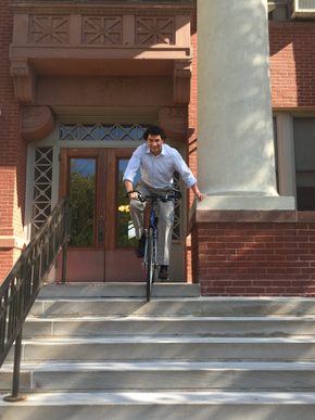 Professor of English Peter Balaam biking down the Laird stairs