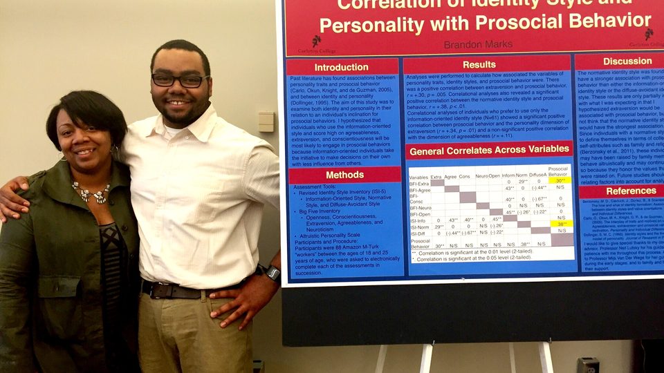 Brandon Marks ‘16 and his mother posing in front of his comps poster on Super Friday.