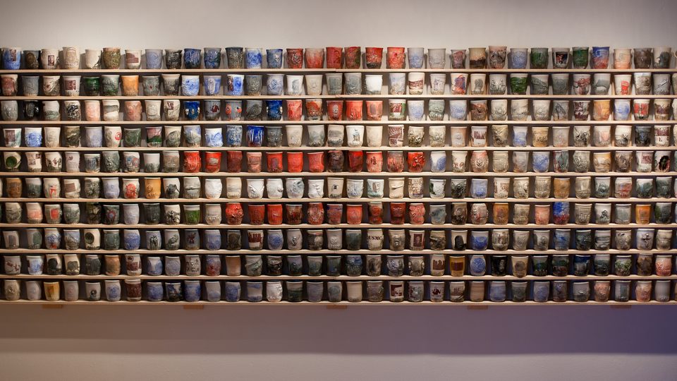 A wall of ceramic cups by artist Ehren Tool.