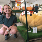 Mabel Frank poses beside a giant pumpkin