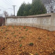 flowers in front of Carleton sign by townhomes