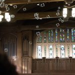 bubbles float with the stained glass chapel windows in the background