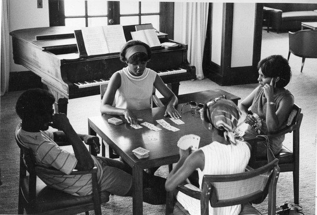 Four college students play cards while sitting at a table. 