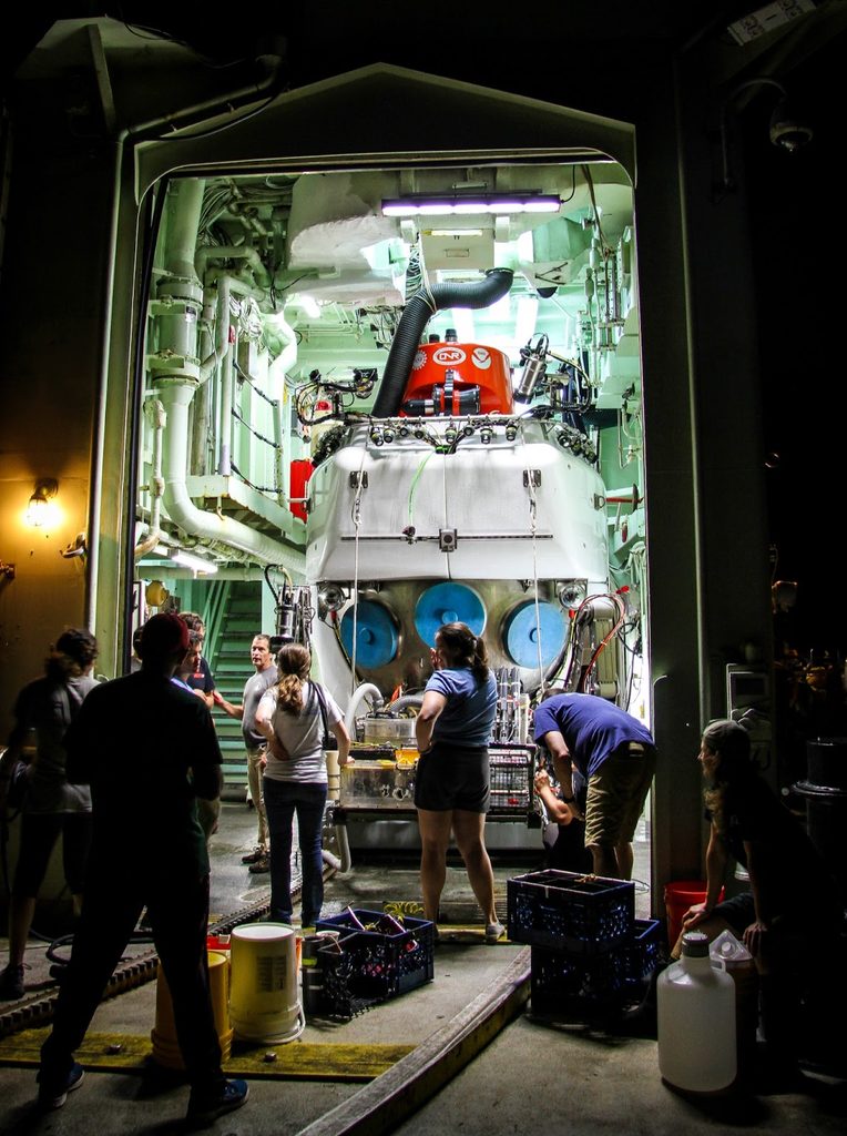 Scientists inspect equipment for deep sea research.