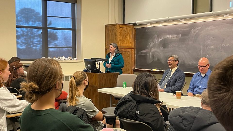 Students and professors sit together in a classroom.