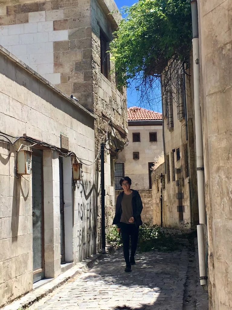 Portrait photo of Yuanhao Zou among old buildings