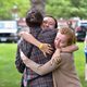Three members of the class of 2020 hug outside the Chapel tent.