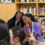 Two students smile and tilt their heads together for a different photo.