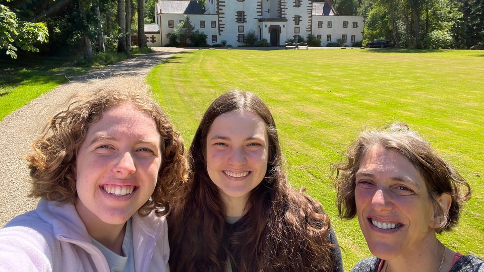 Selfie of Raine Bernhard ’23, Margaret De Fer ’24 and Professor Serena Zabin in front of a castle.