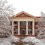 Wide shot of the front of Laird under a white sky, surrounded by snow-covered trees.