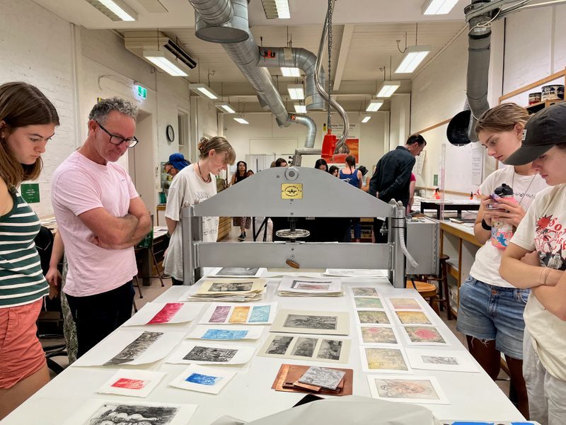 students at workshop looking at prints