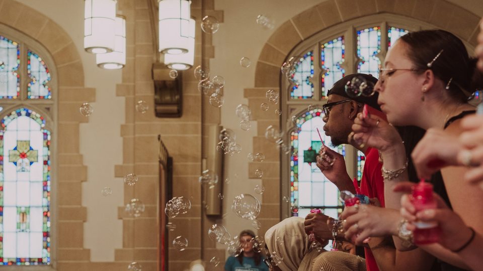 Students blow bubbles from the Chapel balcony.