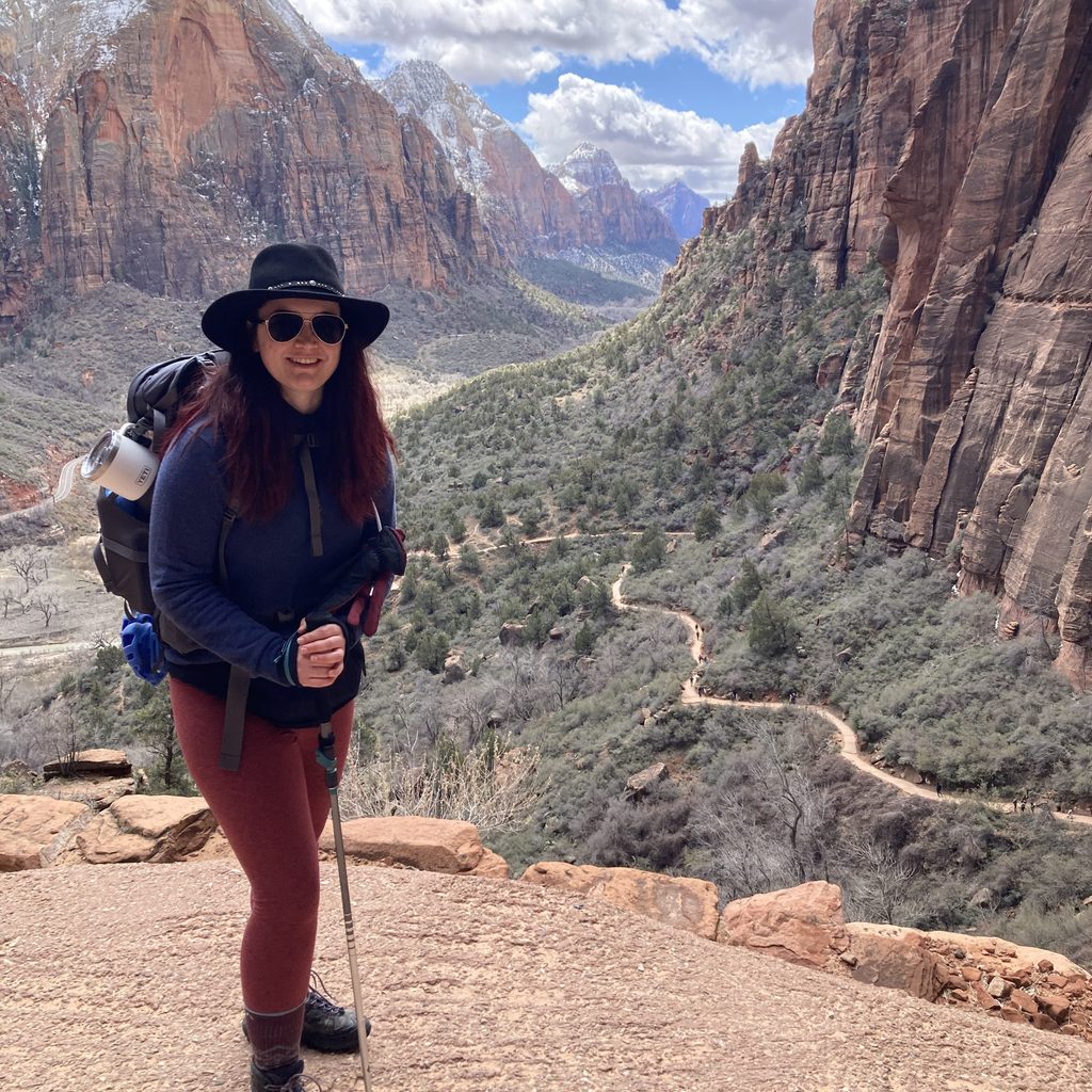 McKenna Wirth ’22 in hiking gear with a valley and mountains behind her.