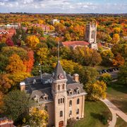 Aerial shot of campus with Willis Hall in the foreground and the Chapel in the middle ground. Trees are in full fall bloom, with oranges, reds and yellows filling the landscape.