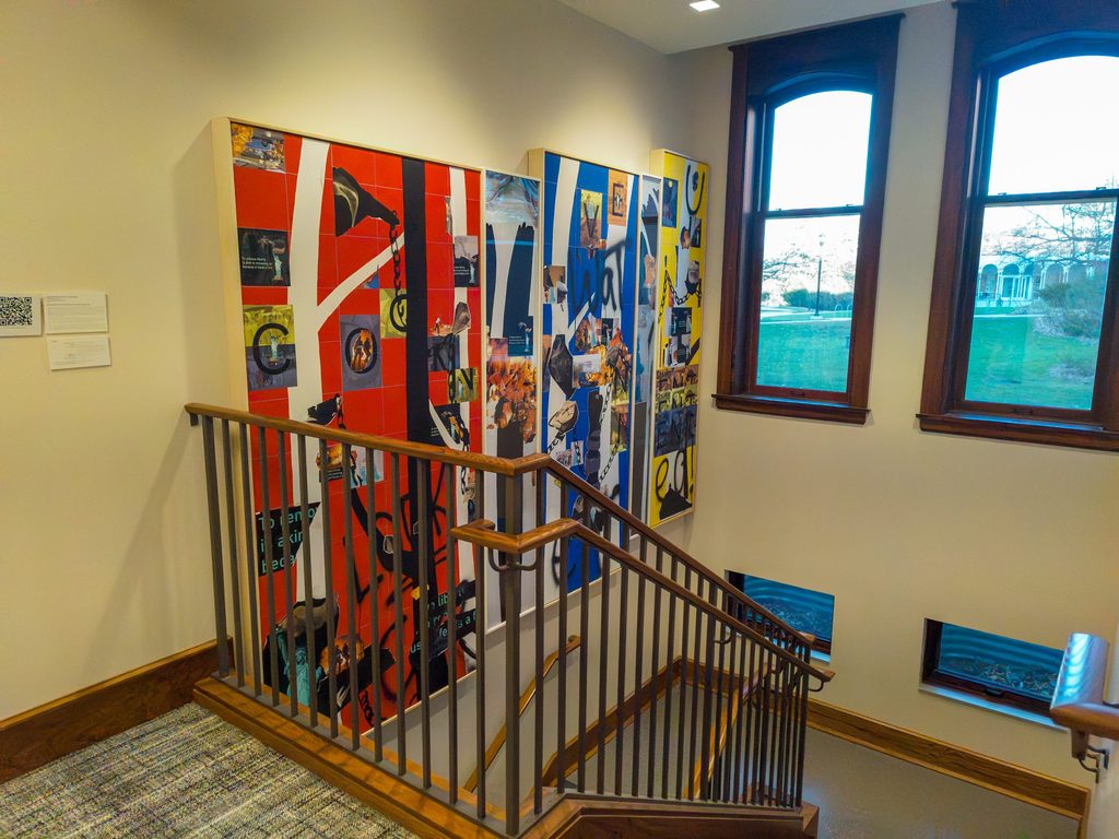 Red, blue and yellow collages behind a stair rail