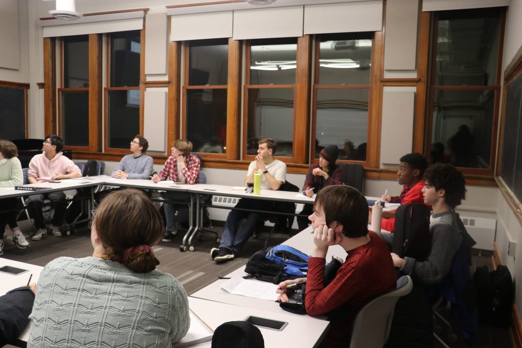 Students sitting at table listening to McCartney at workshop