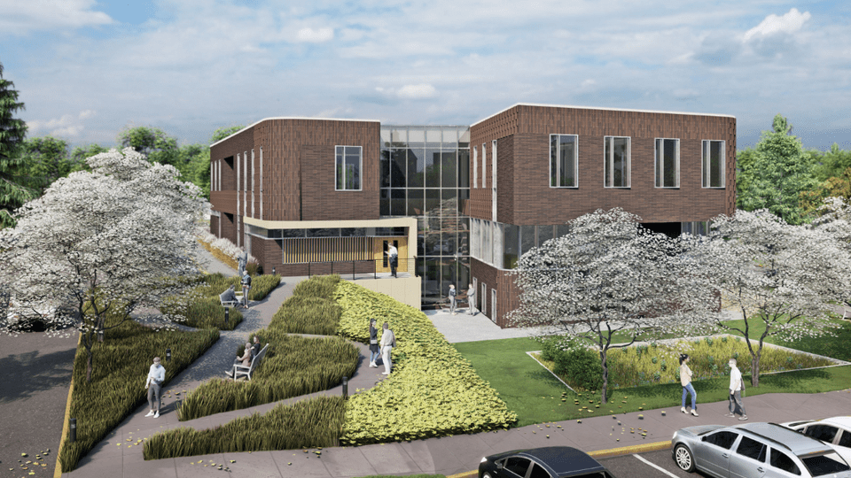 Rendering of a large, brown brick building with big windows, surrounded by grass and trees.