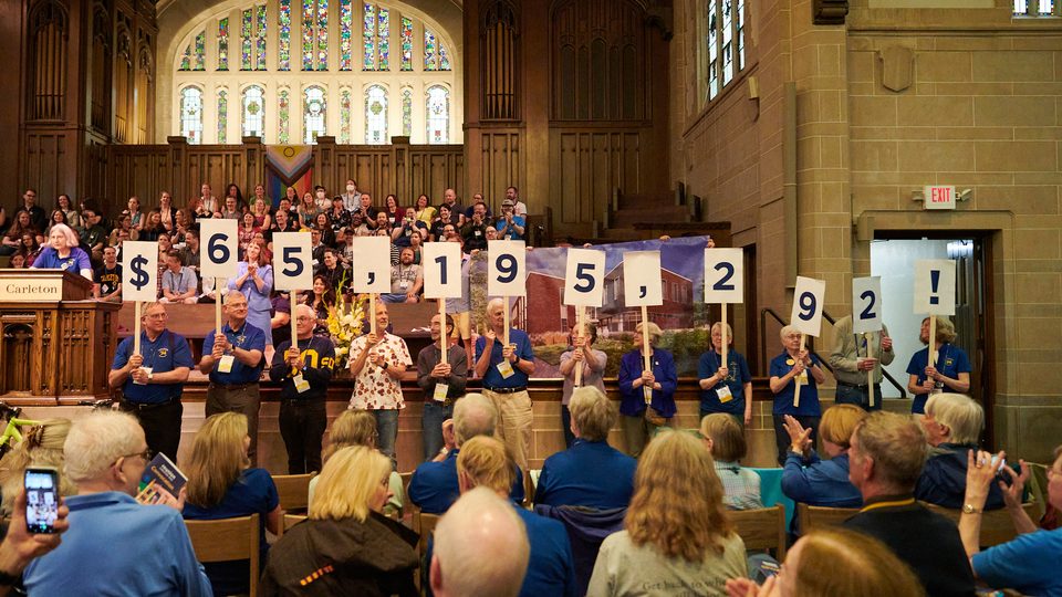 Members of the Carleton Class of 1974 hold up signs that show how much money the class raised for its 50th reunion: $65,195,292.