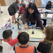 Kids work on a science project with the help of a Carleton student