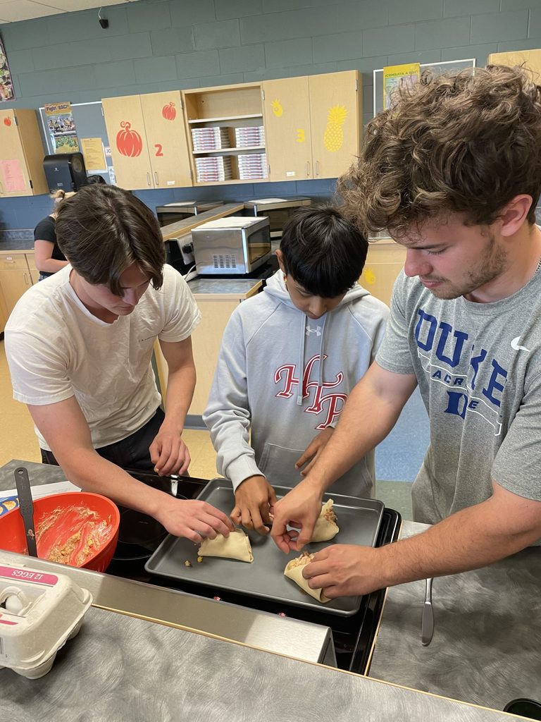 Two students and one student teacher cook together