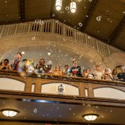 students blowing bubbles off a balcony in the chapel