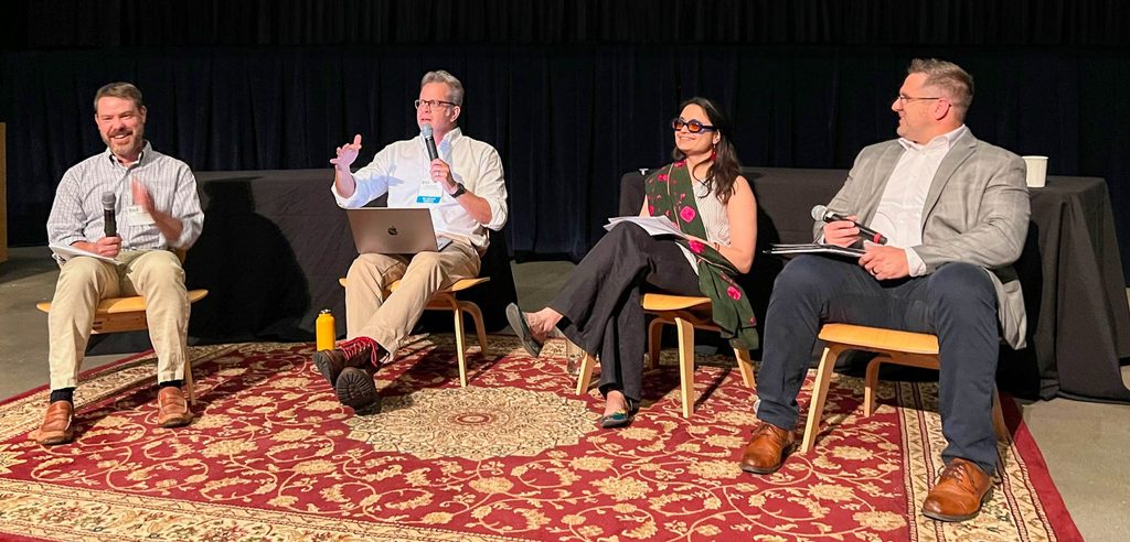 Four people sit and speak.