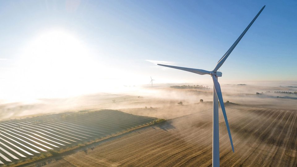 Aerial photo of one of the Carleton wind turbines during a misty early morning.