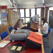 Students in a library looking down at books