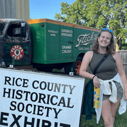Lily Burrows '26 next to a Rice County sign during the Rice County Fair in July.