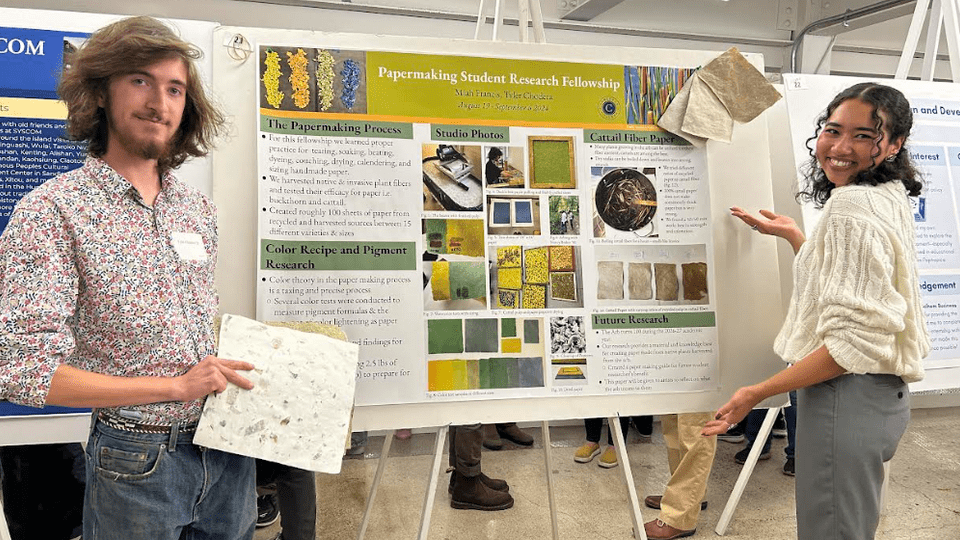 Two students standing in front of a poster