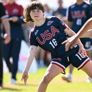 Someone in a Team USA jersey throws a Frisbee.