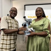 Chérif Keïta presents a microscope to Thembi Ndlovu.
