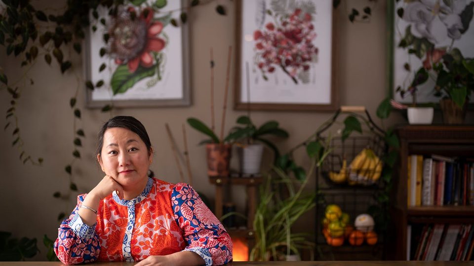 Kao Kalia Yang sits at a table in her home.