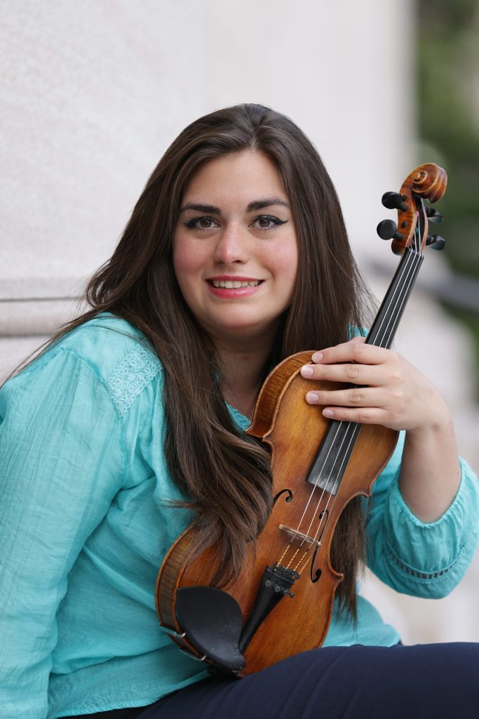 Headshot of Mariela Shaker, holding a violin.