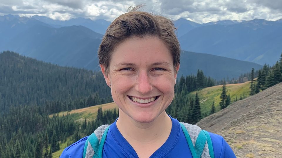 Marina Watowich poses in front of a backdrop of mountains.