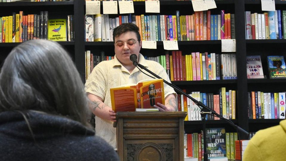 Rafael Frumkin ’12 reading at a podium in Content Bookstore.