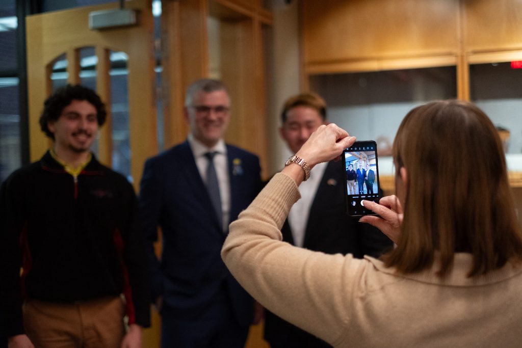 Alison Byerly takes photo of students with Ambassador Prikk 