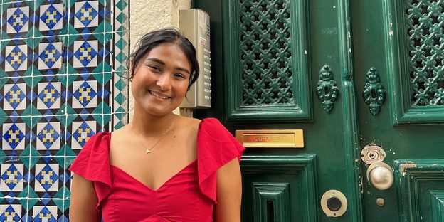 Narjis Nusaibah ’26 poses in front of a green door.