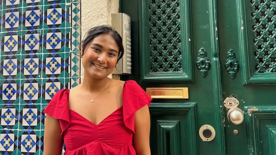 Narjis Nusaibah ’26 poses in front of a green door.