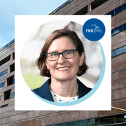 Headshot of Anna Paulson ’87 in the middle of a photo of the Philadelphia Fed.