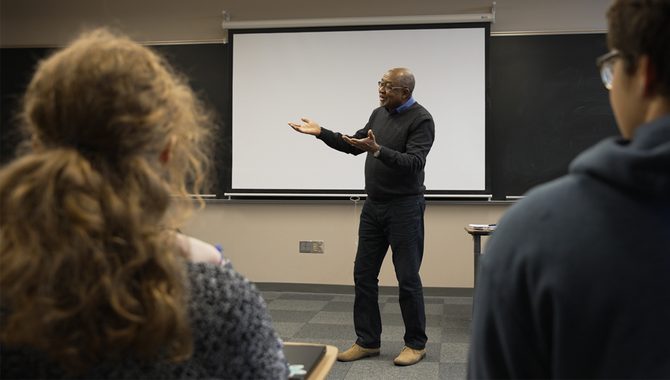 Professor Chérif Keïta gestures at the front of a classroom.