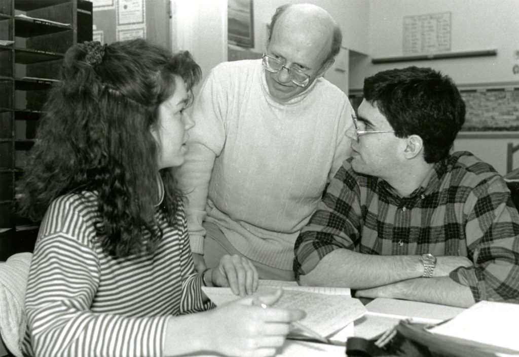 Black and white photo of Russ Petricka helping students.