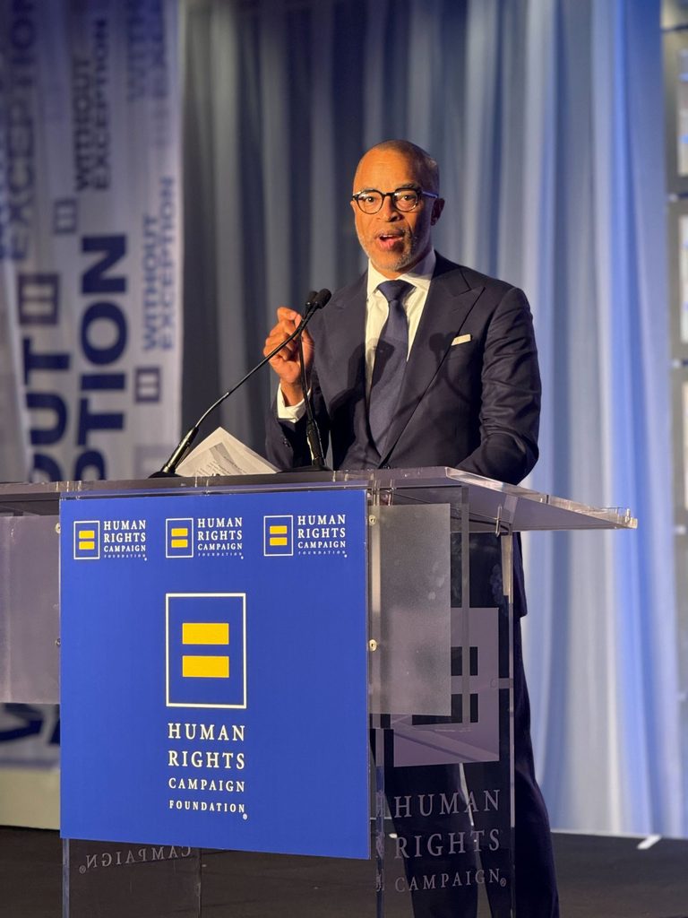 Jonathan Capehart ’89 accepts an award from a podium branded with Human Rights Campaign.
