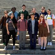 Ten people posing together on steps outdoors.