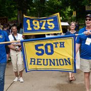 Two people carry a banner reading, 