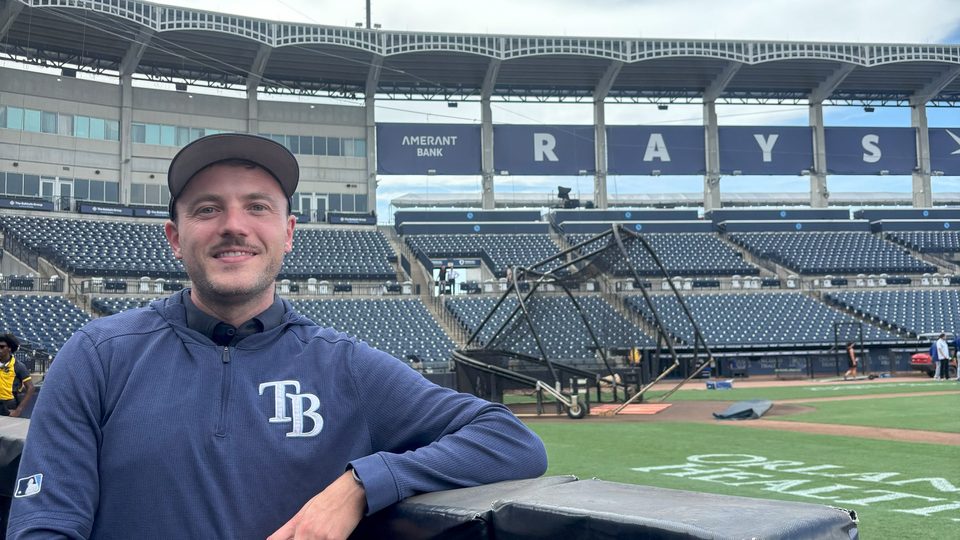 Michael McClellan poses in front of the Tampa Bay Rays baseball field.