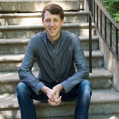 Matthew Olson, sitting outdoors on stairs.