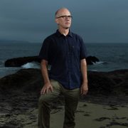 Ben Halpern, posing in front of an ocean background.